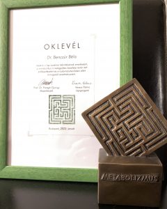 A Metabolizmus-díj bronz kisplasztikája és díszoklevele. Az oklevél felirata: Dr. Benczúr Béla részére, a lap szakmai tekintéylének emeléséért, a metabolikus tünetegyüttes kezelése terén tett erőfeszítéséért és e tudományterületen elért kimagasló eredményeiért. Aláírás: Prof. Dr. Parragh György főszerkesztő, Veress Pálma lapigazgató, Budapest, 2023. január. (beküldött fotó)